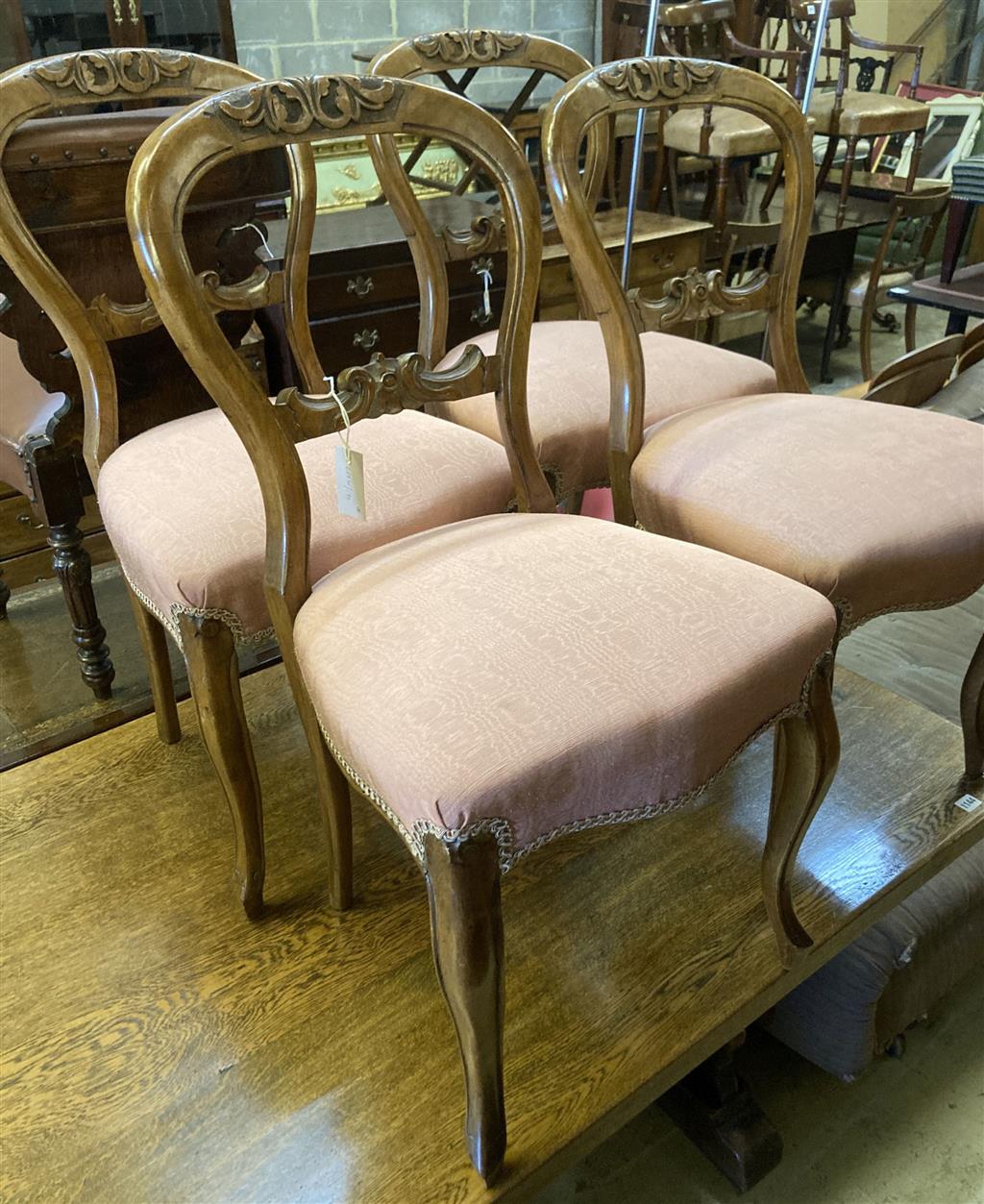 A set of four Victorian walnut balloon back dining chairs